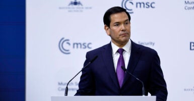 Marco Rubio looks off to his left as he speaks at a podium in front of white background with Munich Security Conference MSC logo.