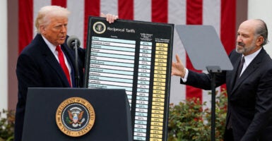 President Donald Trump holds a chart next to U.S. Secretary of Commerce Howard Lutnick as Trump delivers remarks on tariffs in the Rose Garden at the White House in Washington, D.C., U.S., April 2, 2025. REUTERS/Carlos Barria