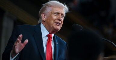 Low angle shot of President Trump, his right hand raised delivering the State of the Union.