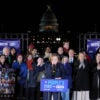 MoveOn Executive Director Katie Bethell speaks during the "People's State of the Union" at the National Mall, with a group of people and U.S. Capitol in background.