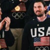 Goalie Connor Hellebuyck raises his gold medal as members of the US Men's Olympic hockey team are recogized by US President Donald Trump as he delivers the State of the Union address in the House Chamber of the US Capitol in Washington, DC, on February 24, 2026. (Photo by ANDREW CABALLERO-REYNOLDS / AFP via Getty Images)