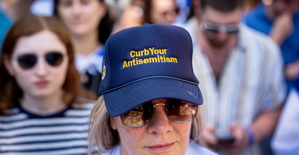 WASHINGTON, DC - MAY 2: A woman wears a hat that reads "Curb Your Antisemitism" during a rally against campus antisemitism at George Washington University on May 2, 2024 in Washington, DC. A pro-Palestinian rally was also held at the school today, as protestors at college campuses around the country call for schools to divest from Israeli interests amid the ongoing war in Gaza. (Photo by Andrew Harnik/Getty Images)