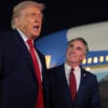 WEST PALM BEACH, FLORIDA - JANUARY 19: U.S. President Donald Trump (L) talks with reporters as U.S. Secretary of the Interior Doug Burgum (R) looks on at Palm Beach International Airport on January 19, 2026 in West Palm Beach, Florida. President Trump attended this year’s college football national championship game at Hard Rock Stadium between the Indiana Hoosiers and the Miami Hurricanes. (Photo by Anna Moneymaker/Getty Images)
