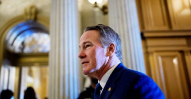 Sen. Jon Husted looks straight ahead as he stands off to the side.