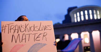 A person holds a sign reading 