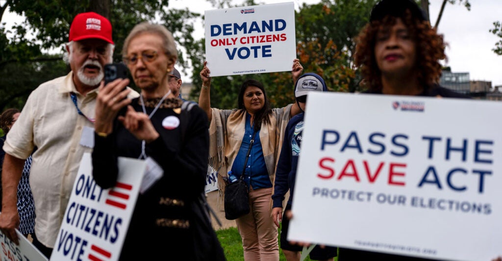 Supporters of the SAVE Act stand with their signs, including one reading, "Demand Only Citizens Vote."