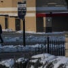 Residents walk by a sign for Springfield, Ohio in the snow.