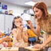 Students and teacher in a school science lab doing activities (Getty images).