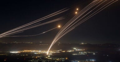 Streaks of light from missile interceptors race into the night sky.
