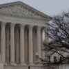 The Supreme Court on a cloudy day, with lone person walking down steps.