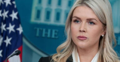 Close-up of Karoline Leavitt in White House Briefing Room.