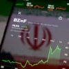 A smartphone showing graph indicating rise in crude oil prices against the background of an Iranian flag.