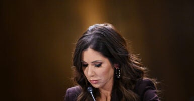 Close up of Kristi Noem in brown suit looking down while testifying.