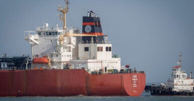 A coastguard boat approaches an Indian liquefied petroleum gas (LPG) carrier, Shivalik, as it arrives in port.