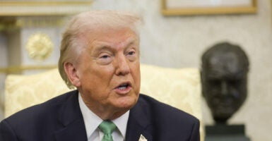 Close up of Donald Trump in Oval Office wearing a green tie.
