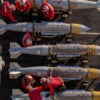 Overhead shot of U.S. Navy crew members inspecting a row of ordinance.