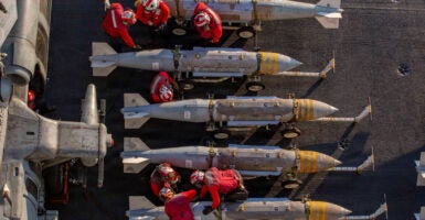 Overhead shot of U.S. Navy crew members inspecting a row of ordinance.