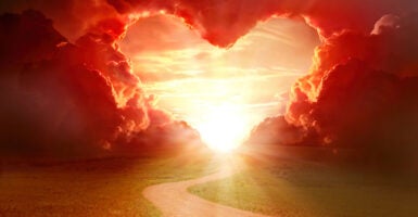 A graphic showing a country road leading toward a sunset with red clouds shaped into a heart.