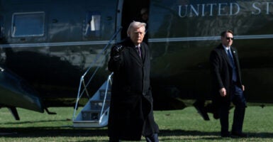 President Donald Trump gestures with his fist as he heads towards Marine One.