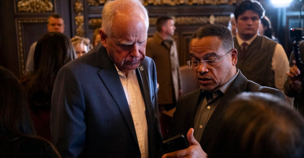 ST. PAUL, MINNESOTA - FEBRUARY 3: Minnesota Attorney General Keith Ellison (R) speaks with Minnesota Gov. Tim Walz (L) after a press conference about federal detention of children at the State Capitol building on February 3, 2026 in St. Paul, Minnesota. Trump administration officials intend to appeal a judges decision to release 5-year-old Liam Conejo Ramos who returned to Minnesota over the weekend after being held in a Texas immigration detention facility. (Photo by Stephen Maturen/Getty Images)