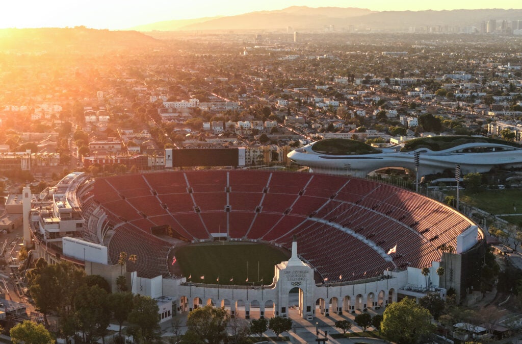 In an aerial view, the Los Angeles Memorial Coliseum and Lucas Museum of Narrative Art (R) in Exposition Park is shown on March 5, 2026 in Los Angeles, California. The stadium will host the 2026 FIFA World Cup and the 2027 LA Olympics.