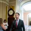 Sen. Tom Cotton walking past a clock.