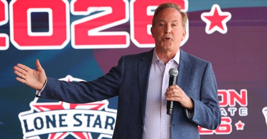 A man holding a microphone and speaking.