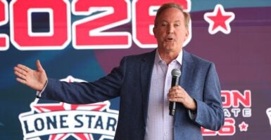 A man holding a microphone and speaking.