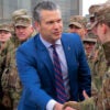 Pete Hegseth shakes hands with troops.