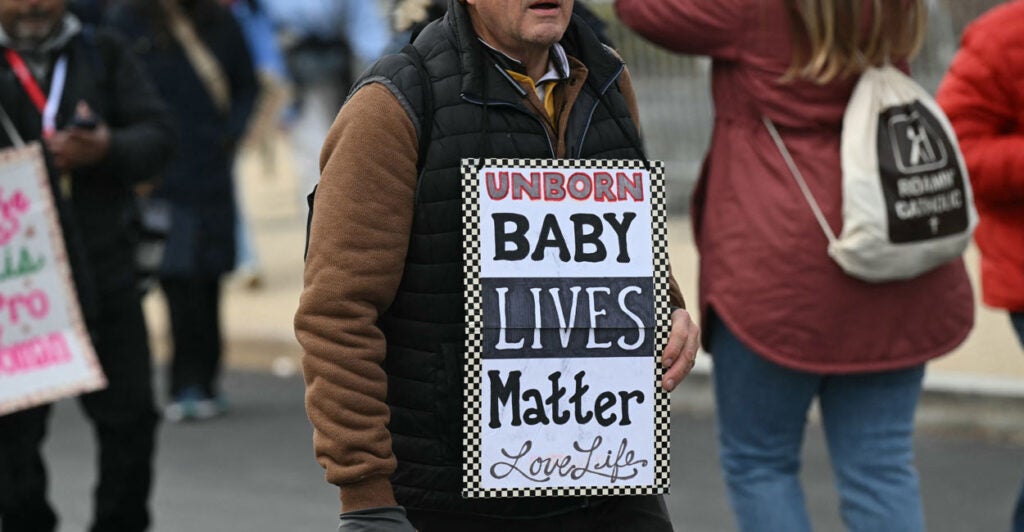 A man holds up a sign, "Unborn Babies Lives Matter: Love Life" at the March for Life.