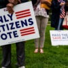 Supporters of the SAVE Act stand with signs, including, "ONLY CITIZENS VOTE."