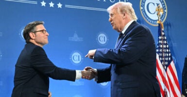 President Trump shakes Speaker Johnson's hand at Doral Florida Republican retreat.
