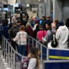 People wait in long TSA lines as the partial government shutdown continues for several weeks at airports like Chicago.