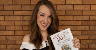 Author Emma Waters holding a copy of Lead Like Jael.