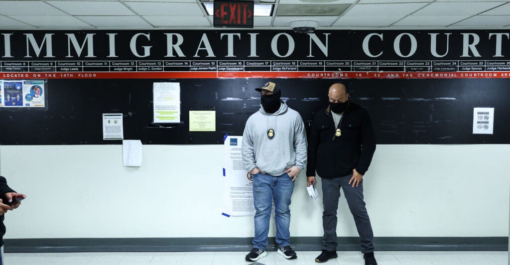 Masked federal agents stand in a hallway at the New York Federal Plaza Immigration Court inside the Jacob K. Javitz Federal Building in New York on March 5, 2026. US President Donald Trump has made deporting undocumented immigrants a key priority for his second term, after successfully campaigning against an alleged "invasion" by criminals. (Photo by CHARLY TRIBALLEAU / AFP via Getty Images)