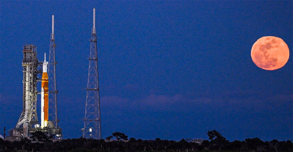 A full moon rises as the Space Launch System (SLS) rocket and the Orion spacecraft, integrated for the Artemis II mission, are seen at Launch Pad 39B at the Kennedy Space Center in Cape Canaveral, Florida, on February 1, 2026 ahead of the first crewed mission to the Moon in more than 50 years. (Photo by Miguel J. Rodriguez Carrillo / AFP via Getty Images)