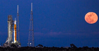 A full moon rises as the Space Launch System (SLS) rocket and the Orion spacecraft, integrated for the Artemis II mission, are seen at Launch Pad 39B at the Kennedy Space Center in Cape Canaveral, Florida, on February 1, 2026 ahead of the first crewed mission to the Moon in more than 50 years. (Photo by Miguel J. Rodriguez Carrillo / AFP via Getty Images)