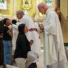 Boston, MA - April 23: Rev. James Wallace, C.Ss.R., distributes communion to a parishioner during afternoon Mass at the Basilica of Our Lady of Perpetual Help on April 23, 2025. The Redemptorists have ministered to this parish since its founding in 1870, serving a congregation that now includes immigrants from Ethiopia, Nigeria, and Haiti Wikipedia alongside longtime members. Despite Catholic identification in Boston falling from nearly one-third of adults in 2014 to 24% in 2023-2024, the basilica remains committed to nurturing a strong, open, and inclusive congregation that reflects the city's changing demographics. (Photo by Erin Clark/The Boston Globe via Getty Images)