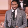 Atlanta Mayor Andre Dickens, in a grey pinstripe suit, speaks at a podium.