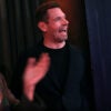 Eric Swalwell, in a black shirt, laughs alongside actress Sophia Bush.
