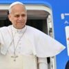 Pope Leo waves before boarding a plane, a female flight attendant at his side.
