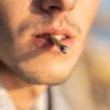 Extreme close-up of a male smoking a joint.