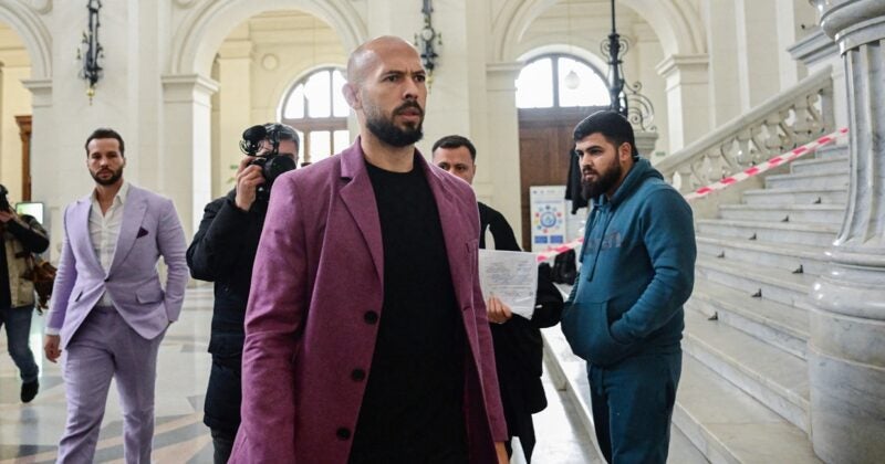 Andrew Tate walking with other men behind him