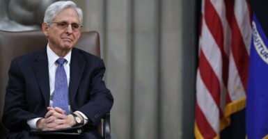 Merrick Garland seated by an American flag