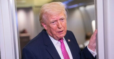 President Donald Trump speaks to reporters on Air Force One