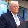 President Donald Trump stands behind a podium in the White House briefing room.