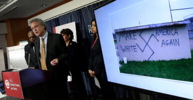 Southern Poverty Law Center then-President Richard Cohen in front of a sign reading "Make America White Again"
